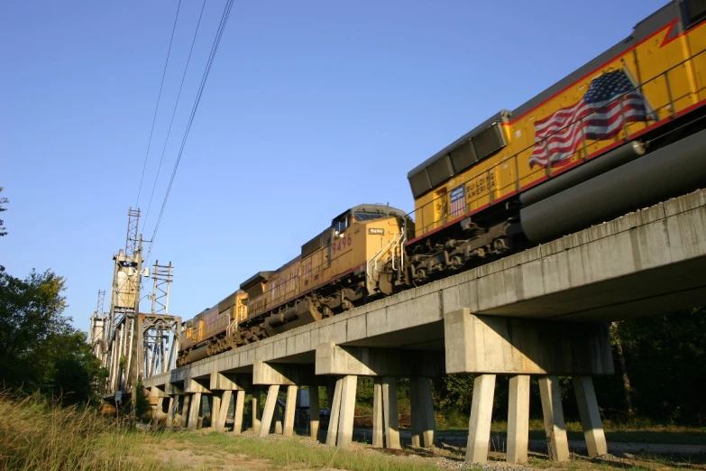 a train on top of a bridge next to power lines