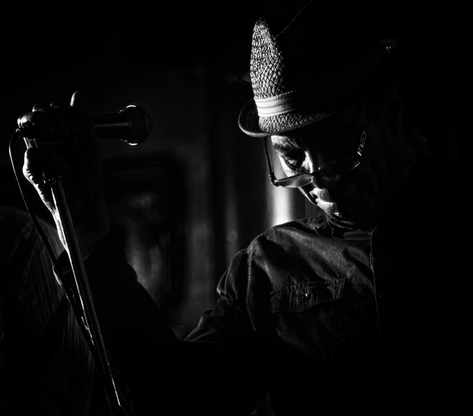 a man wearing a hat holds a microphone