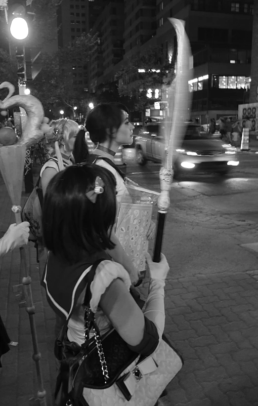 two people standing on a street corner one holding an umbrella