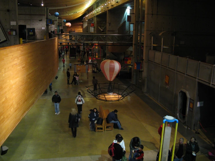 a group of people walking through a dark, lit building