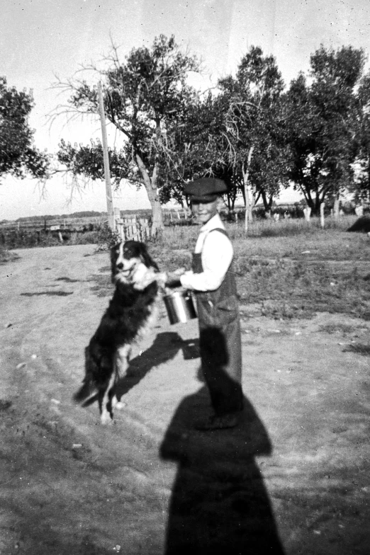 old pograph of man standing with his dog near basketball goal