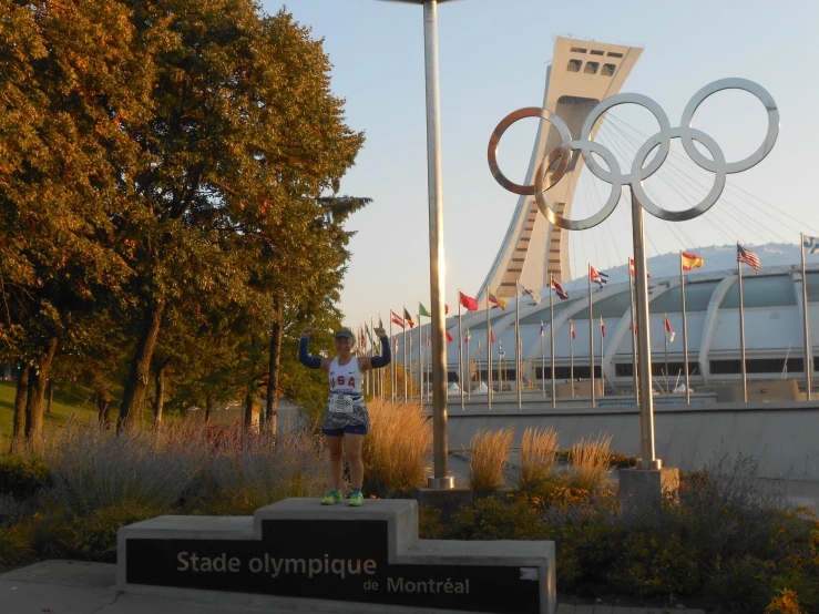 a man is standing on a bench by the olympic rings