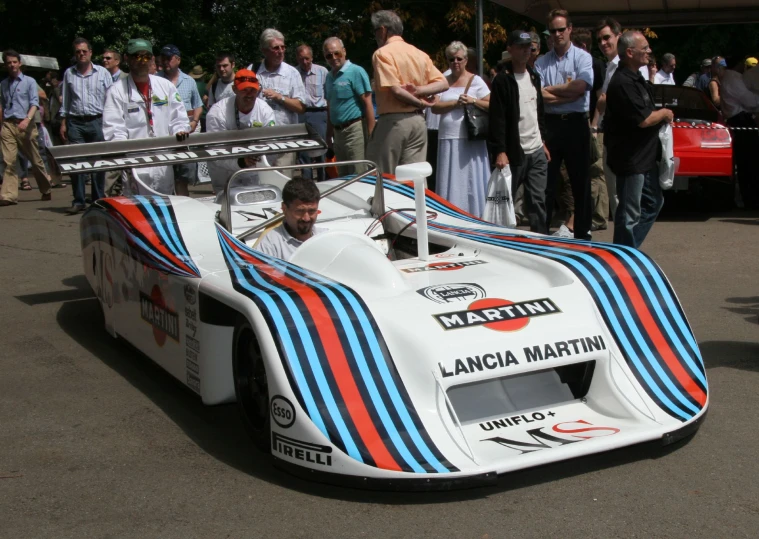 a racing car with people watching from the side