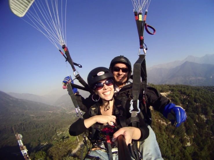 a couple flying through the air while holding on to some strings