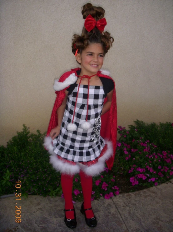 a young lady in a christmas outfit posing for the camera