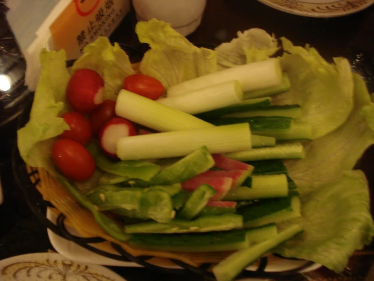 a basket filled with lettuce and tomatoes