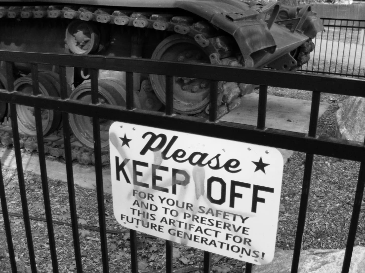 a sign attached to a fence warns about an attraction in the park