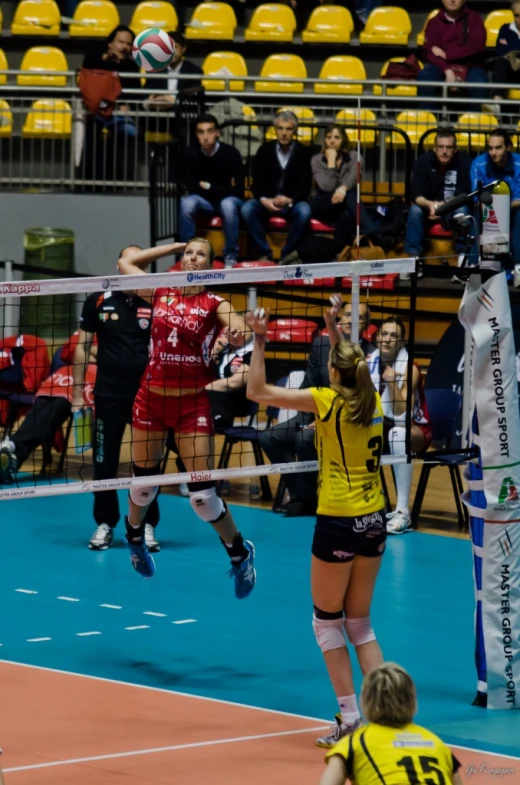 two female volleyball players in action on the court