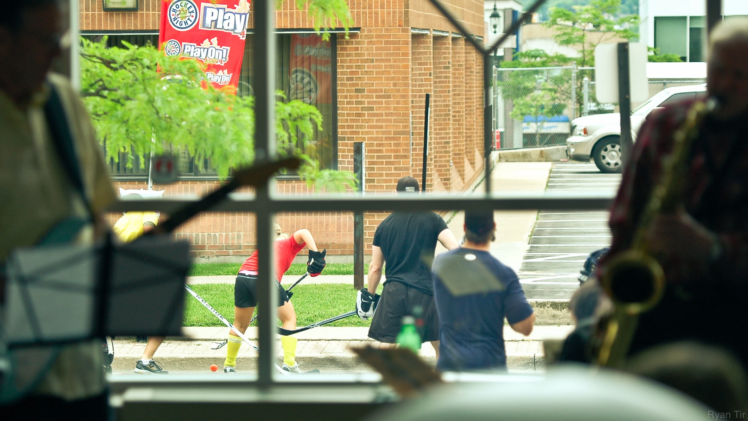 people walking on a sidewalk through an open window