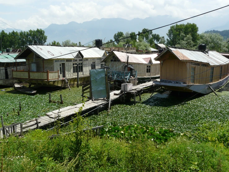 old boats sitting next to small houses in the grass