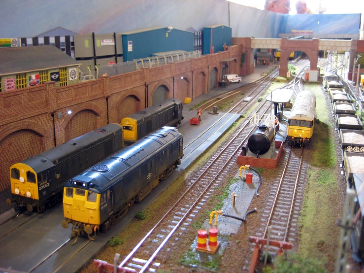 a model of trains on train tracks near brick building
