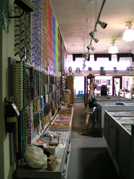 two women look at a table with many necklaces