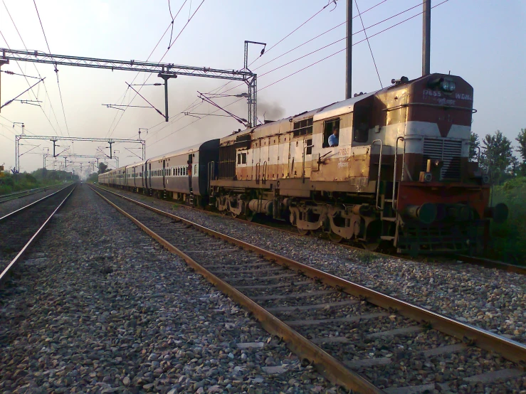 an amtrak train moves down the tracks as the sun is going down