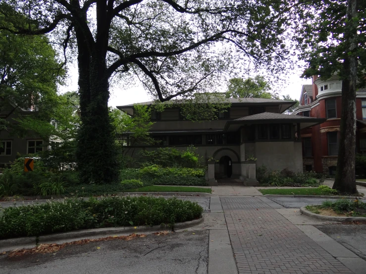 a driveway in front of houses that are surrounded by green trees