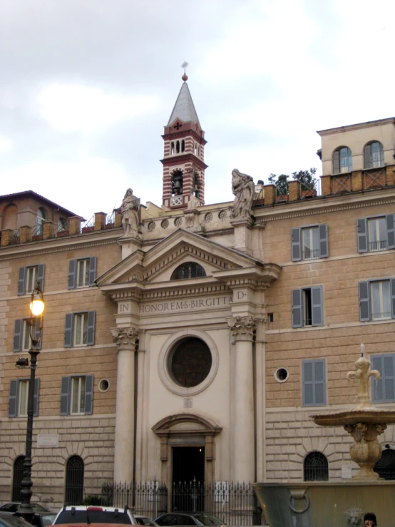 a large cathedral with a clock tower behind a fenced in area