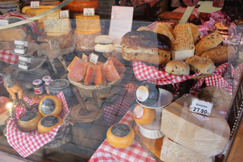 a window display full of bread, buns and cheese