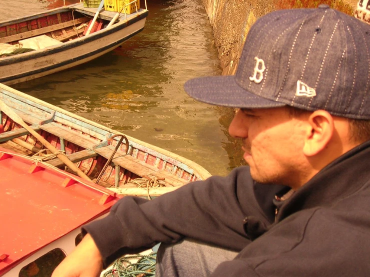 a man is on the side of a river in front of two small boats