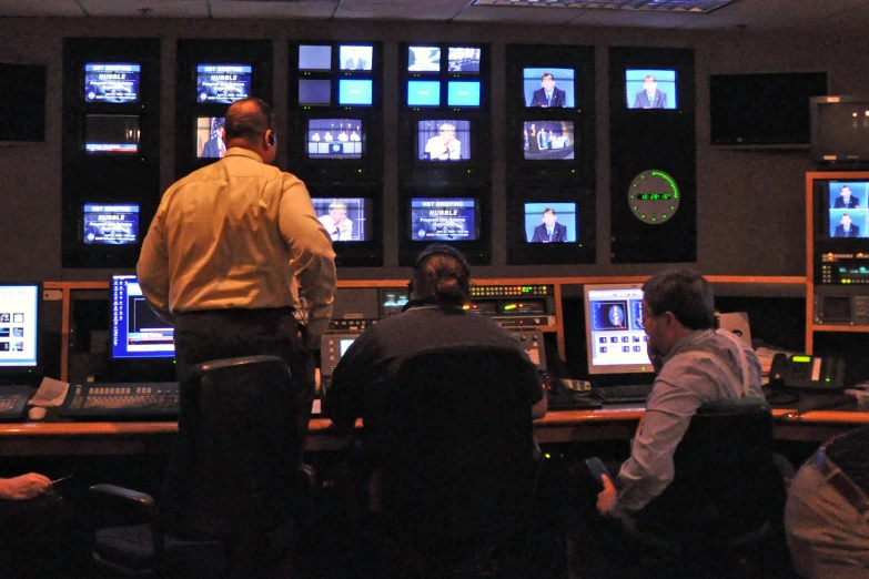 an operator at a large control room looking at video monitors