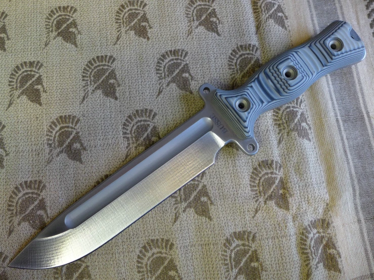 a silver and black knife on top of a table cloth