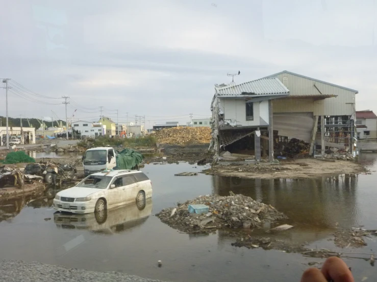 a car is parked in the water in front of an unfinished house