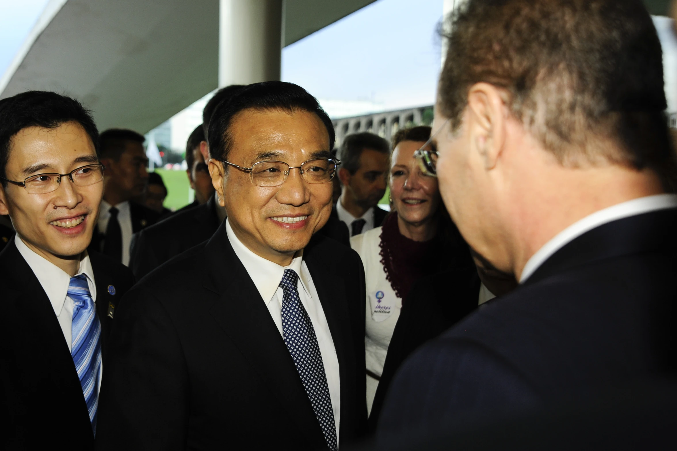 two men standing next to each other in suits