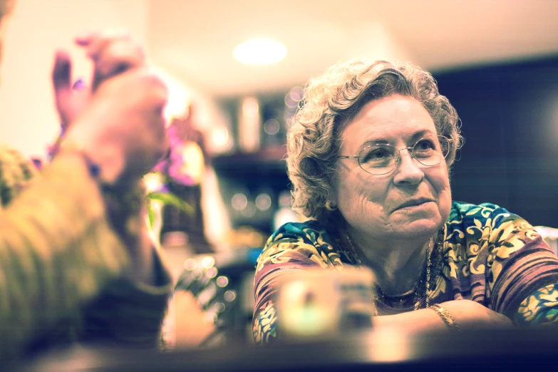 an old woman is holding a glass of wine
