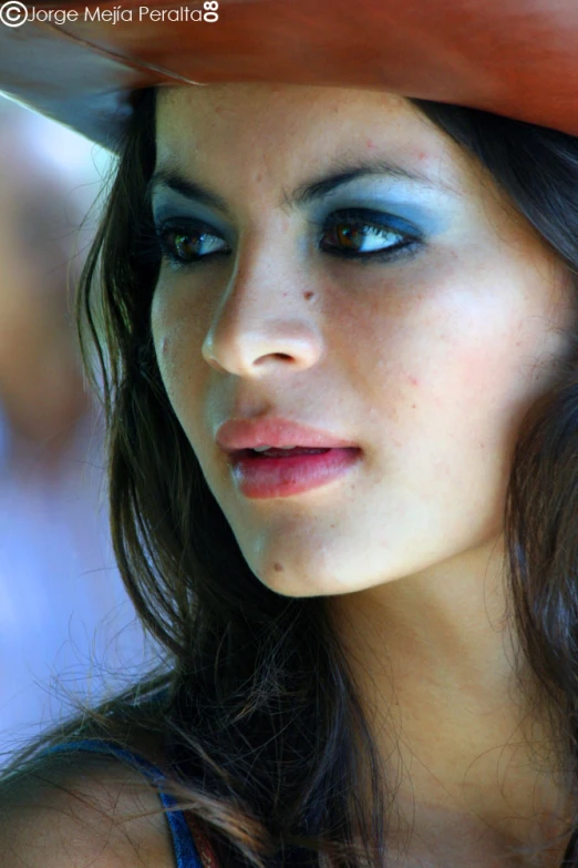 a close - up po of a woman with blue eyes wearing a hat