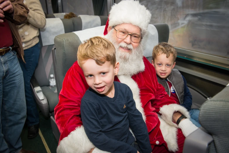 a child with santa clause on sitting next to a man