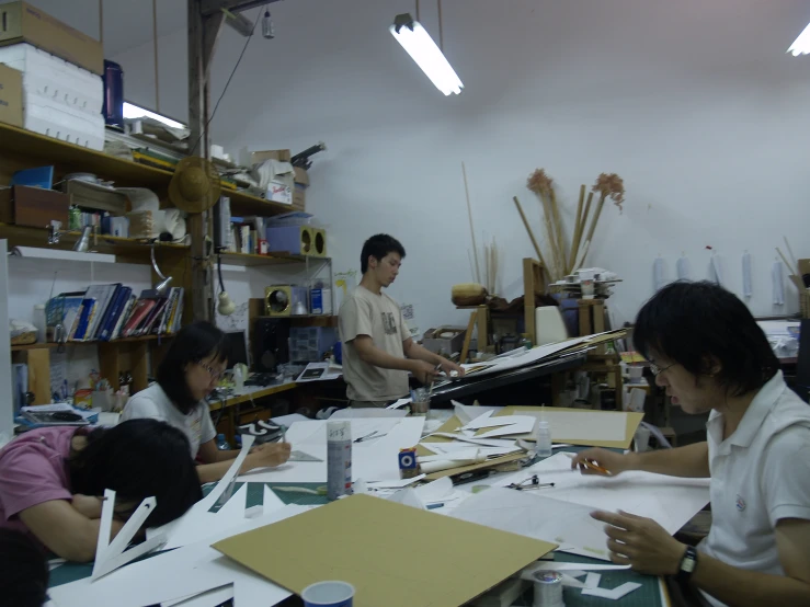 a group of people sitting around a table in a workroom