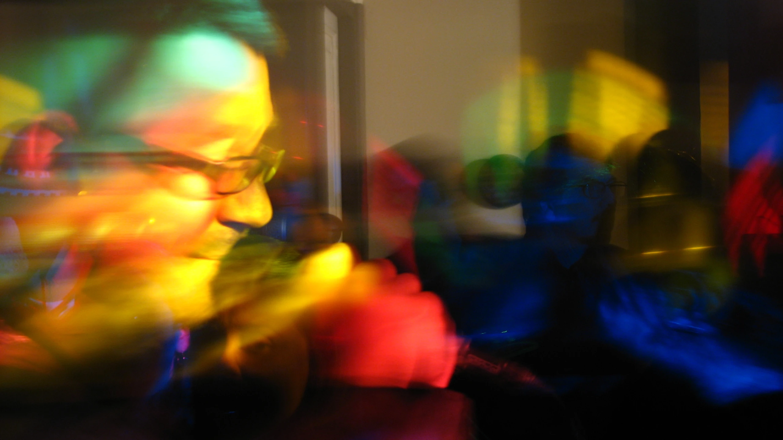 a blurry po of people in a room with multicolored lights