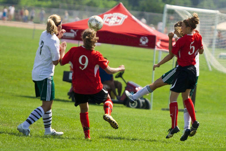 soccer players leap up to head the ball