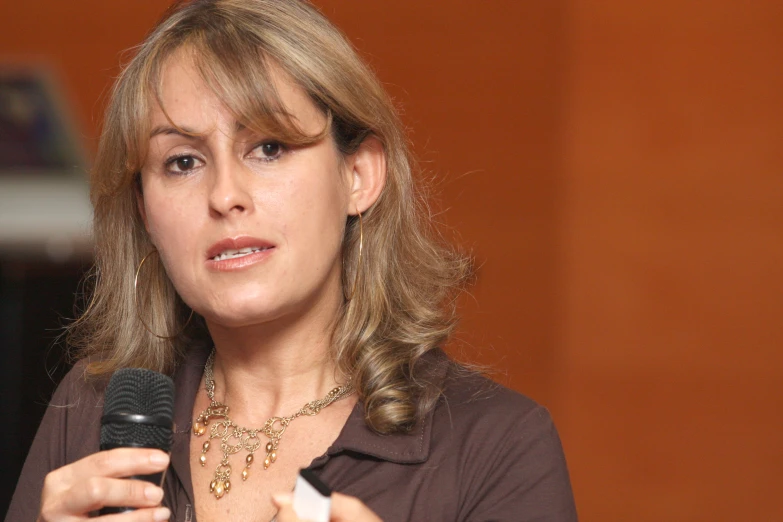 a woman holds a microphone with her right hand