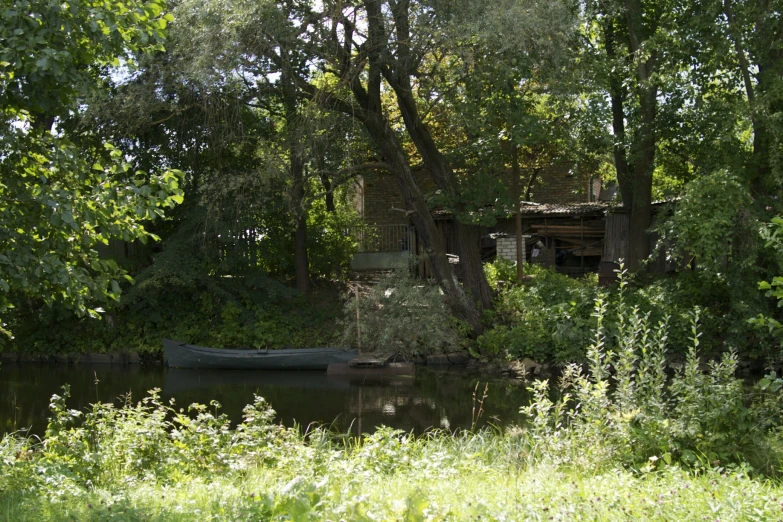 a small boat is in the lake under the tree