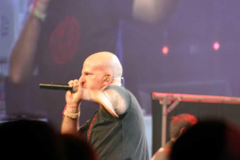 a man in a black shirt sings into a microphone