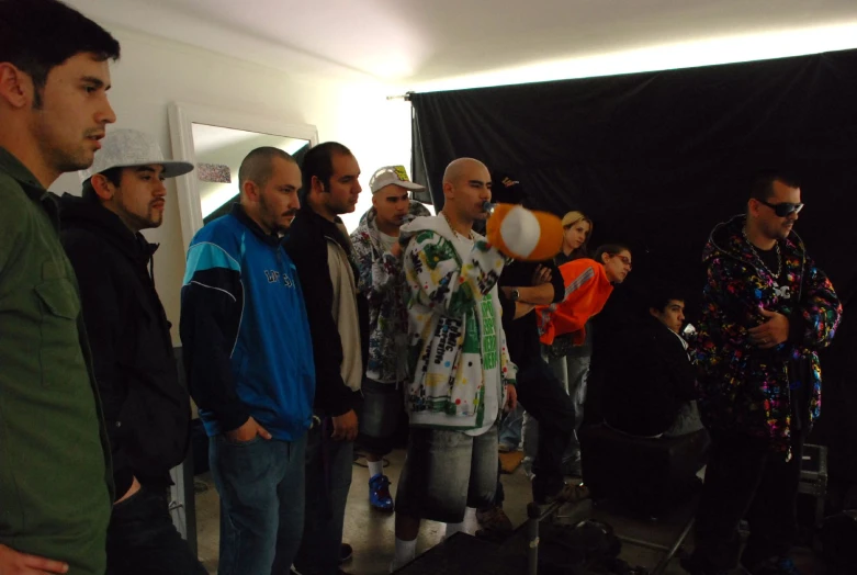 a group of people are gathered around a black backdrop