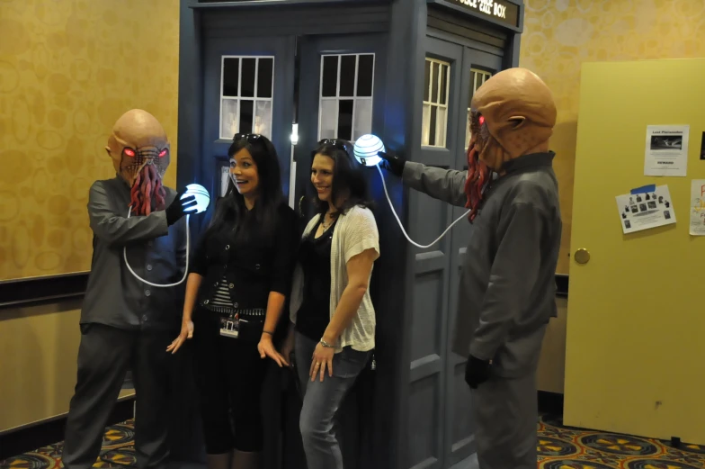 four people dressed as doctor who have light up glowing hands