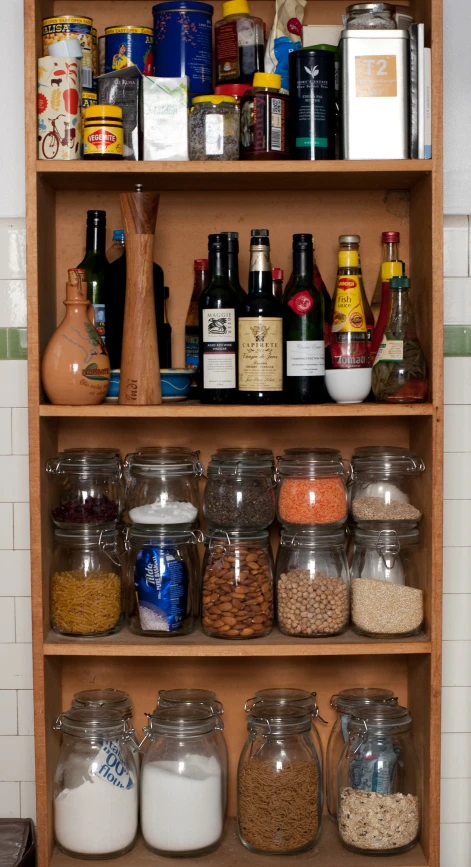 a wood shelf with many different kinds of jars