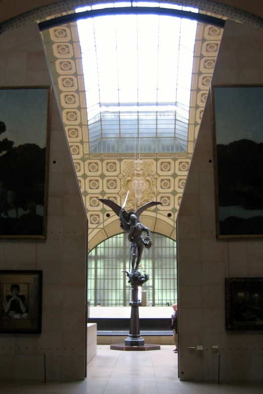 a statue on display in a building with windows above