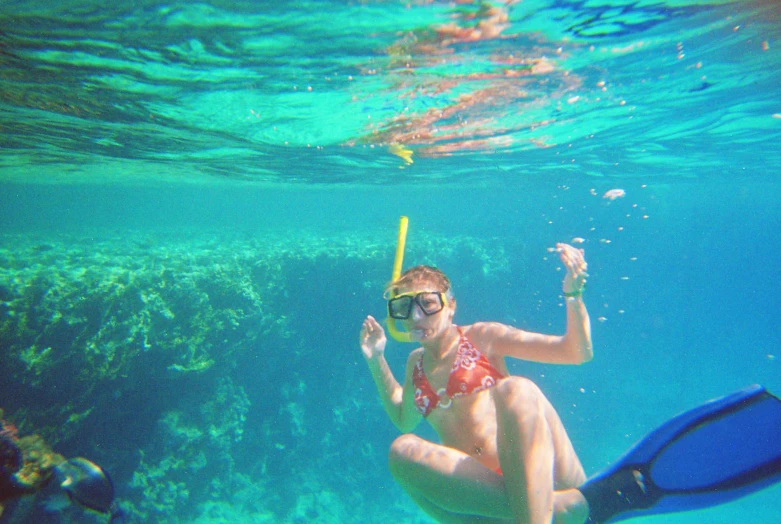 a woman wearing a snorkel on her back is in the ocean with snorkes