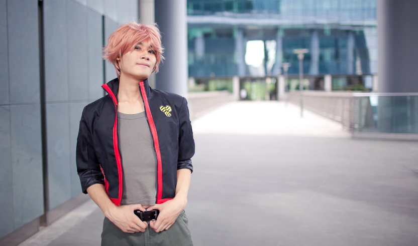 a woman with pink hair standing by a large building