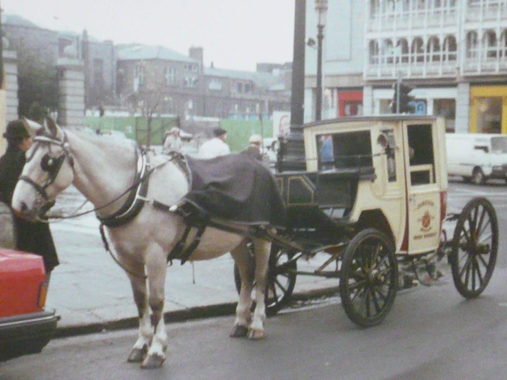 horse - drawn carriage with a man in the passenger seat on a city street