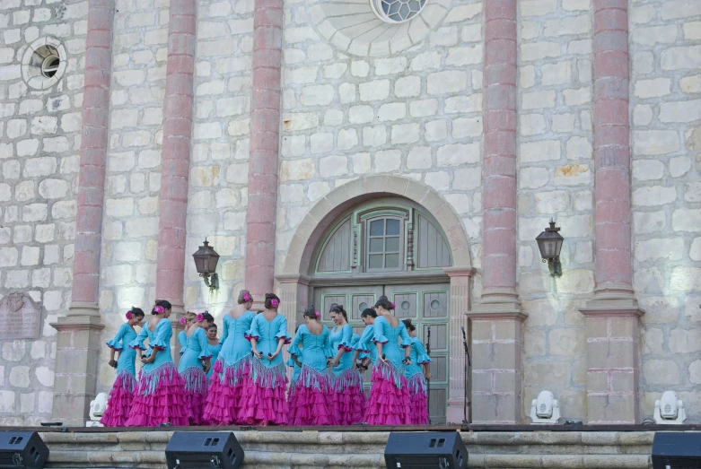 the dancers are dressed in bright colors standing together