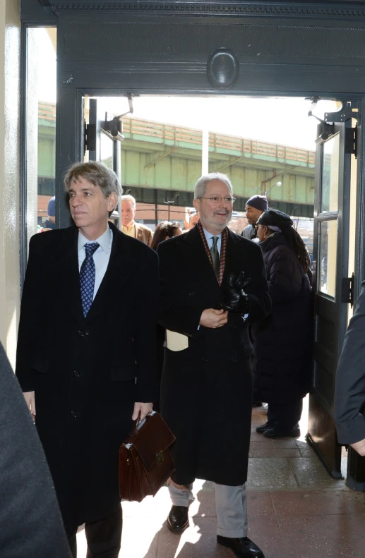 three men in suits and tie walking next to each other