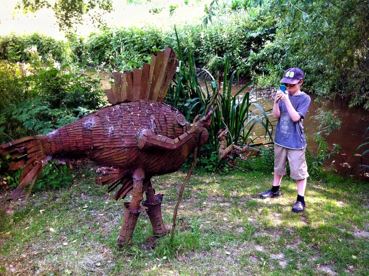 a person taking a picture of a sculpture of an animal