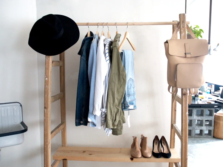 a shelf holding a hat, shoes and a coat rack