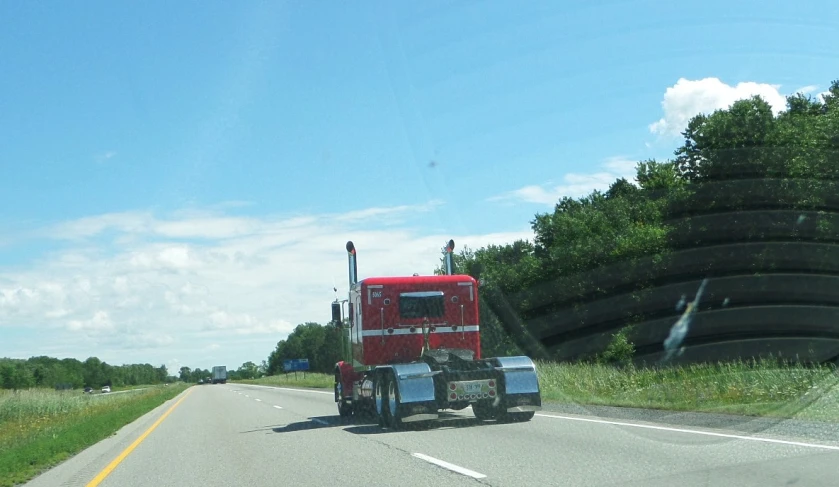 a truck drives down the road on a sunny day