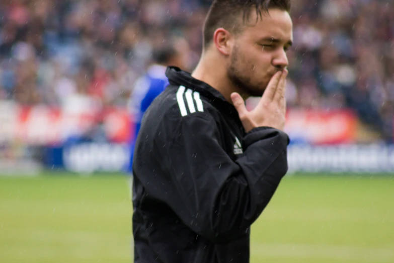 a soccer player stands at attention during a game