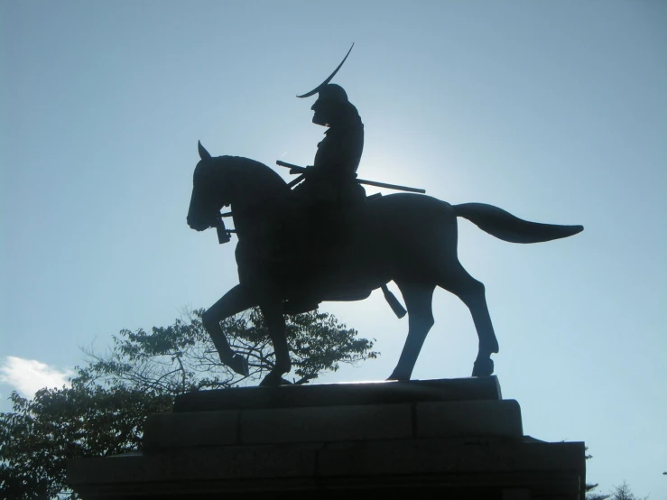a statue of a man on a horse near a tree