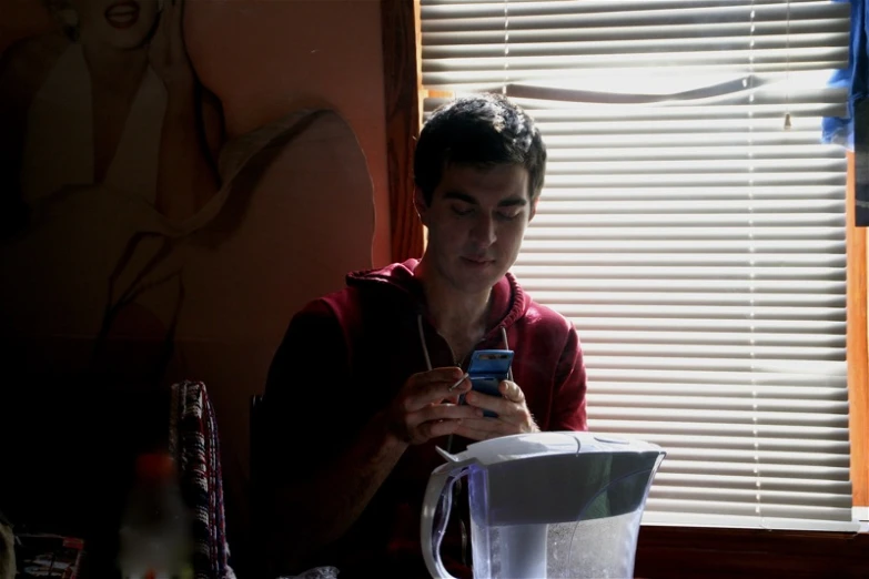 a person sitting at a table with a cell phone