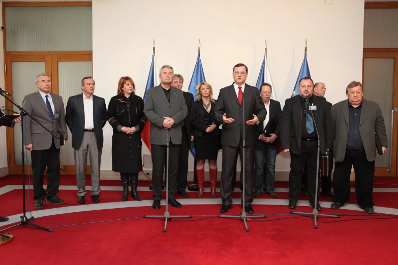 people standing on a stage holding a microphone in front of two other people